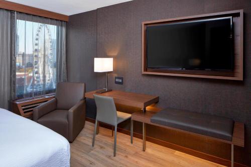 een hotelkamer met een bureau en een flatscreen-tv bij AC Hotel Atlanta Downtown in Atlanta