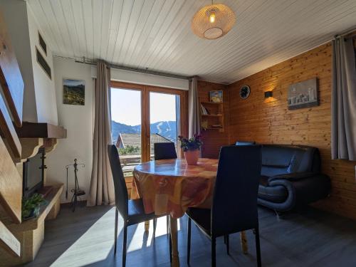 une salle à manger avec une table et des chaises et une fenêtre dans l'établissement Chalet familial avec cheminée à Gérardmer - FR-1-589-37, à Gérardmer
