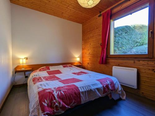 ein Schlafzimmer mit einem Bett in einem Zimmer mit einem Fenster in der Unterkunft Chalet familial avec cheminée à Gérardmer - FR-1-589-37 in Gérardmer