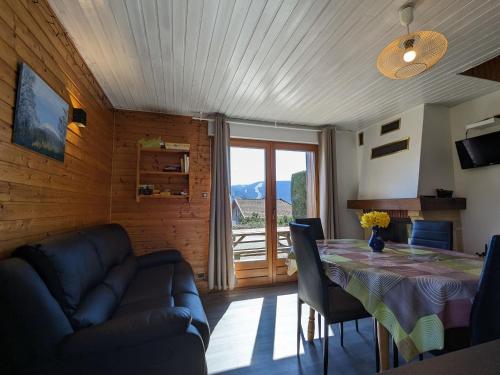 un salon avec une table et un canapé dans l'établissement Chalet convivial à Gérardmer avec cheminée, proche du lac et des pistes, idéal famille et rando - FR-1-589-95, à Gérardmer