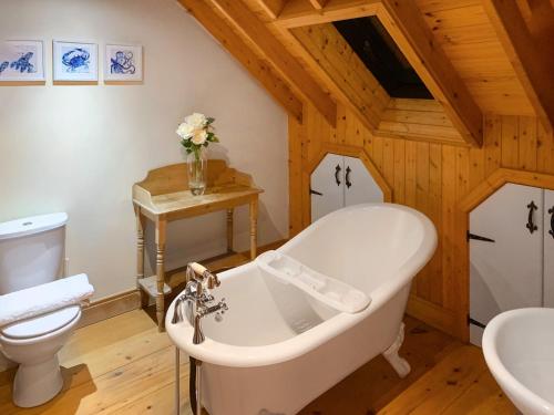 bagno con vasca bianca e servizi igienici di Seaton Cottage - Uk31990 a Staithes