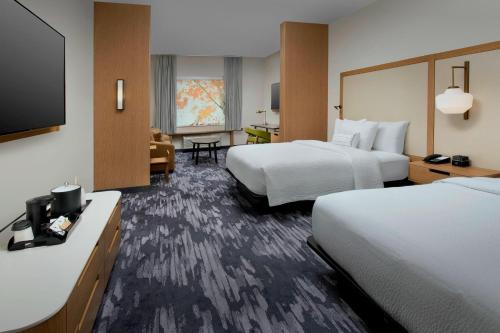 a hotel room with two beds and a flat screen tv at Fairfield Inn & Suites by Marriott Miami Airport West/Doral in Miami
