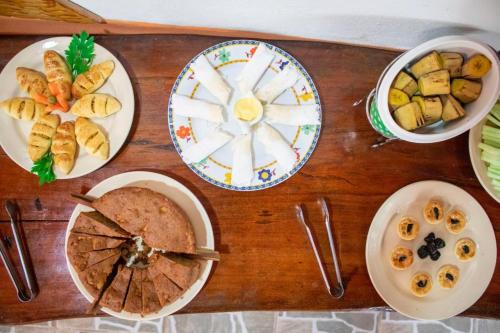 Una mesa de madera con platos de comida encima. en Pousada Velho Garimpo, en Lençóis