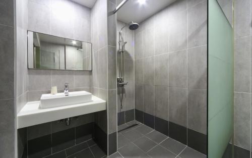 uma casa de banho com um lavatório e um chuveiro em Yeonsan Oops Hotel em Busan