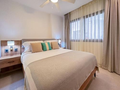 Un dormitorio con una cama grande y una ventana en Apto de 2 hab y 2 bañ swim up a pasos de la playa en Punta Cana