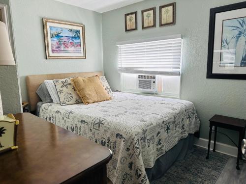 a small bedroom with a bed and a window at Across bridge to Palm Beaches! Great Price for 3 Bedroom House! Sleeps 5 Fenced Backyard Deck Grill Firepit!Close to Downtown in Lake Worth