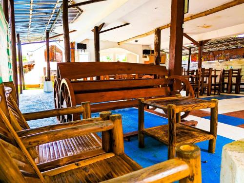 a group of wooden benches sitting inside of a building at Czar's Place in Siquijor