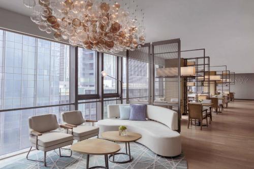 a living room with a couch and chairs and a chandelier at Courtyard by Marriott Shenzhen Bay in Shenzhen