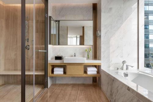深セン市にあるCourtyard by Marriott Shenzhen Bayのバスルーム(洗面台、鏡付)