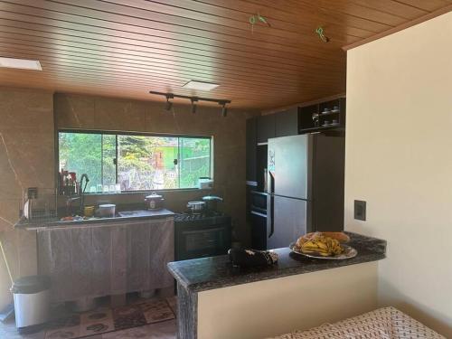 a kitchen with a refrigerator and a plate of fruit on a counter at Casa beiramar Provetá IlhaGrande in Angra dos Reis