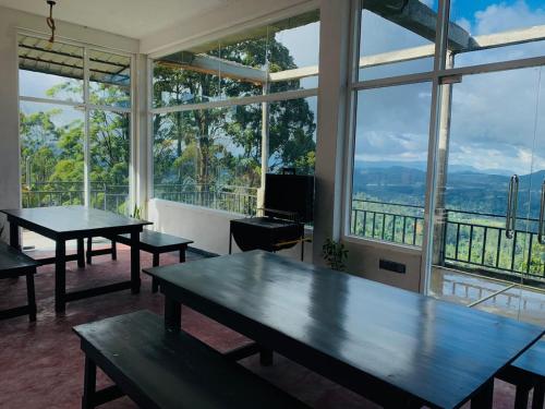 two tables in a room with large windows at The Station Lodge in Haputale