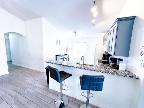 a kitchen with a counter and two blue chairs at *Home in davenport Cheerful 5-bedroom with pool in Davenport