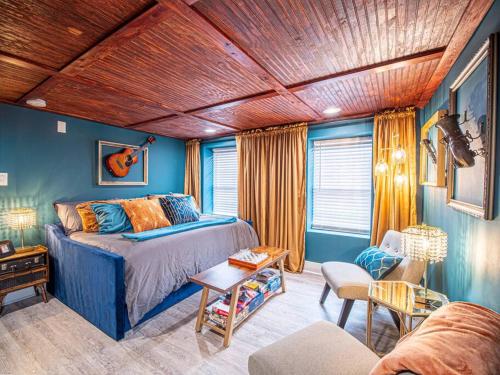 1 dormitorio con paredes azules, 1 cama y 1 sofá en Rhythmic Escape, en Marietta
