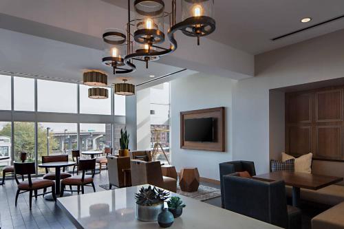 a dining room with tables and chairs and a television at Omaha Marriott Downtown at the Capitol District in Omaha