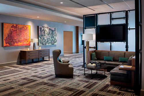 a living room with a couch and a flat screen tv at Omaha Marriott Downtown at the Capitol District in Omaha