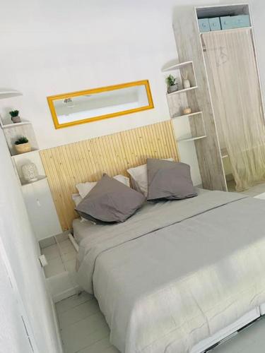 a bedroom with a bed with two pillows on it at Le Grey House in Saint-François