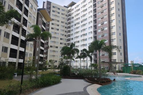 an apartment complex with a swimming pool and palm trees at Avida Atria Tower I Cozy Condo Great Location in Iloilo City