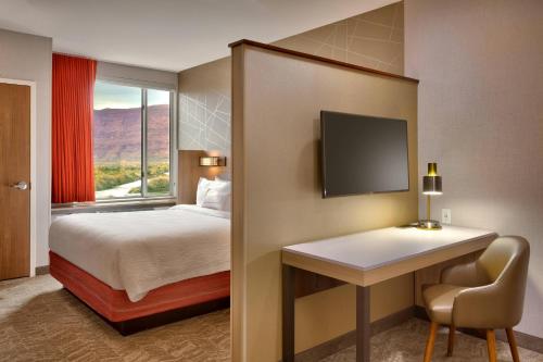 Pokój hotelowy z łóżkiem, biurkiem i oknem w obiekcie SpringHill Suites by Marriott Moab w mieście Moab