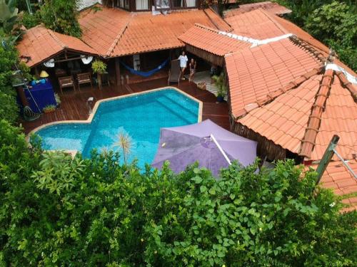 - une vue sur la piscine avec un parasol dans l'établissement Pousada Bawa, à Ubatuba
