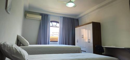 a bedroom with two beds and a window at CAXU HOSTEL in Cachoeiro de Itapemirim
