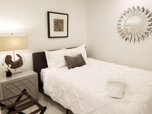 a bedroom with a large white bed and a mirror at 9BR-SLEEPS 19. Amazing Deal!! in New Orleans
