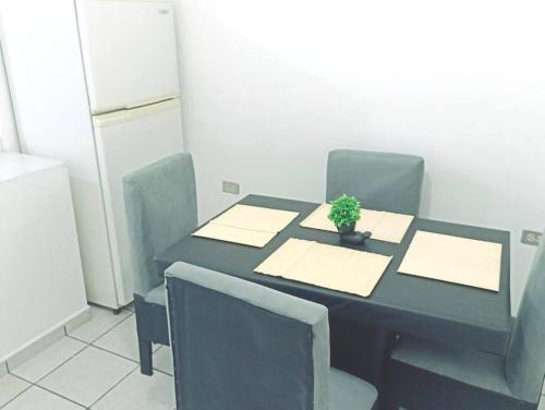 a black table with chairs and a potted plant on it at Departamento Completo, Centro Histórico Durango in Durango