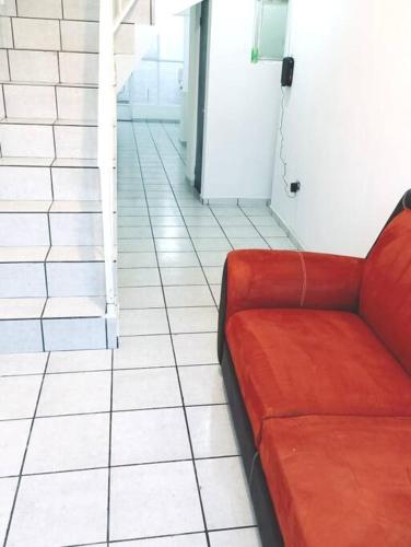 a red couch sitting on a tiled floor at Departamento Completo, Centro Histórico Durango in Durango