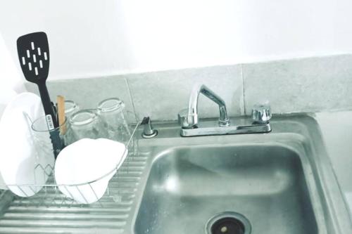 a kitchen sink with a spatula and a whisk at Departamento Completo, Centro Histórico Durango in Durango