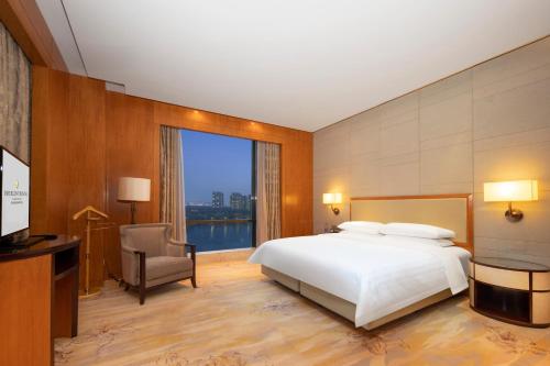 a bedroom with a bed and a desk and a window at InterContinental Changzhou by IHG in Changzhou