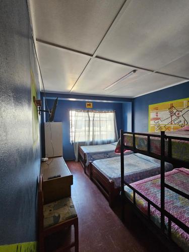 a room with three bunk beds and a window at Hostal Copa Arica in Arica