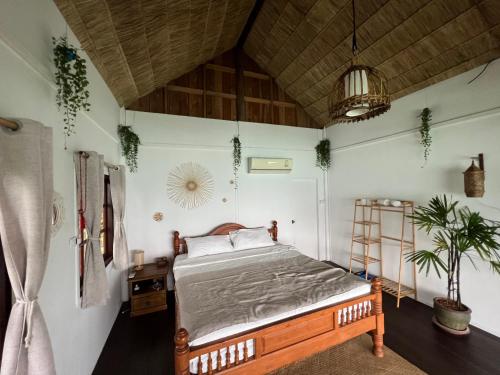 - une chambre avec un lit dans une pièce dotée d'un plafond dans l'établissement Hidden Viewpoint House, à Mae Haad