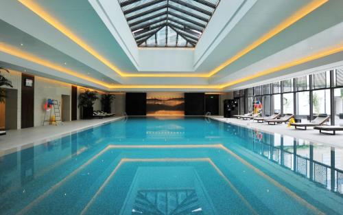 a large swimming pool in a building at Jinling Hotel in Nanjing