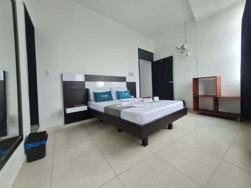 a bedroom with a bed with blue pillows at Hotel colina del meta in Villavicencio