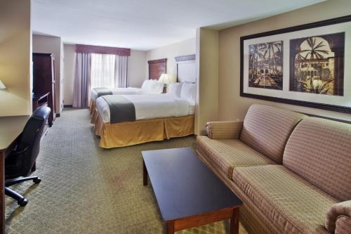 a hotel room with two beds and a couch at Holiday Inn Express Savannah Airport, an IHG Hotel in Savannah