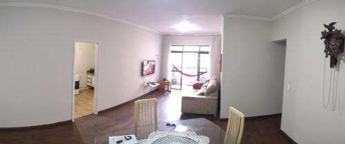uma sala de jantar e sala de estar com mesa e cadeiras em ACONCHEGO SANTOS em Santos