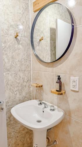 y baño con lavabo blanco y espejo. en Vieja Irupé en Concepción del Uruguay