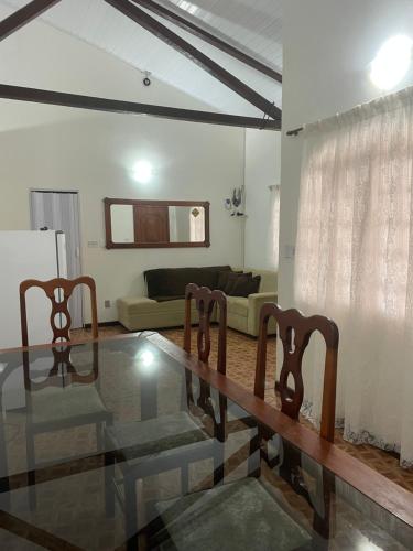 a living room with a glass table and chairs at Pousada Recanto dos Sonhos in Alto Paraíso de Goiás