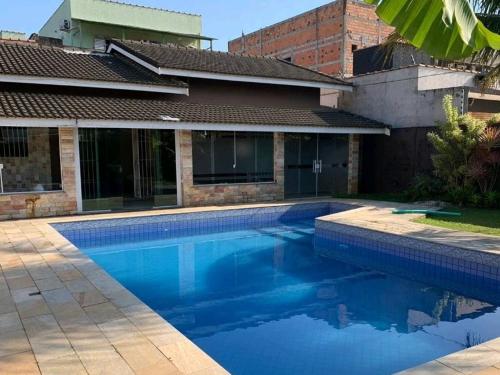 una piscina frente a una casa en Casa de Praia com Piscina em Peruíbe, en Peruíbe
