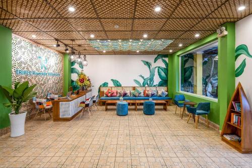 a waiting room with green walls and blue chairs at TRIPLE Riverside Villa Hotel HoiAn in Hoi An