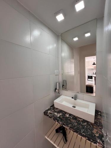 a white bathroom with a sink and a mirror at URBAN 483 in La Falda