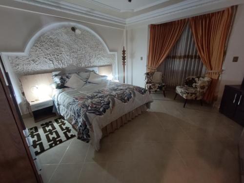 a bedroom with a large bed and a chair at Hermoso departamento familiar in Sucre