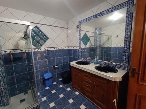 a bathroom with two sinks and a shower and a mirror at Hermoso departamento familiar in Sucre