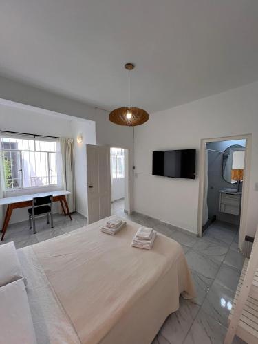 a bedroom with a large bed and a flat screen tv at URBAN 483 in La Falda