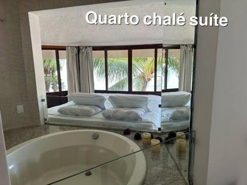 a bathroom with a tub and a bed with a window at Casa beira-mar centro de pipa in Pipa