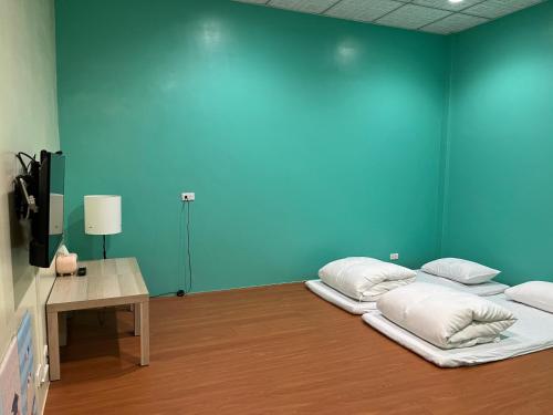 um quarto com duas camas e uma parede azul em 日升咖啡民宿 em Gukeng