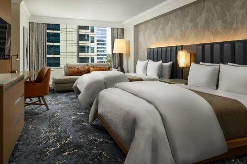a hotel room with two beds and a couch at The Westin Bellevue in Bellevue