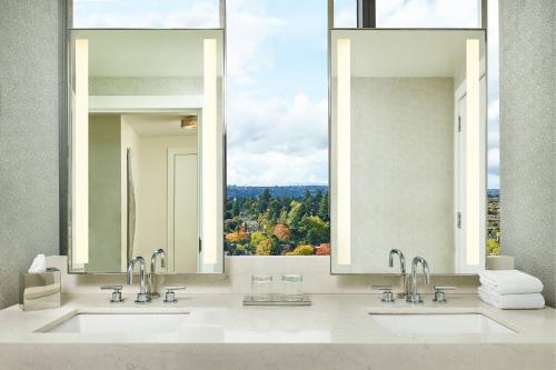 a bathroom with two sinks and a large window at The Westin Bellevue in Bellevue