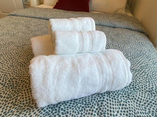 quatro toalhas empilhadas em cima de uma cama em Dockside Luxury Living Bedroom Bathroom em Whitby