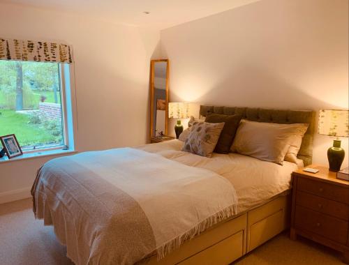 um quarto com uma cama grande e uma janela em Private Apartment at Woodland Retreat em Gamlingay