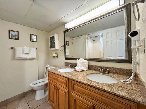 ein Badezimmer mit einem Waschbecken, einem WC und einem Spiegel in der Unterkunft Ocean Front at Beach Cove in Myrtle Beach